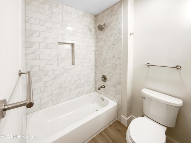 bathroom with toilet, tiled shower / bath combo, and wood-type flooring