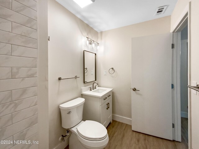 bathroom featuring vanity, toilet, and hardwood / wood-style flooring