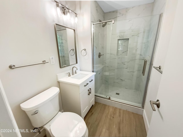 bathroom featuring hardwood / wood-style flooring, vanity, an enclosed shower, and toilet