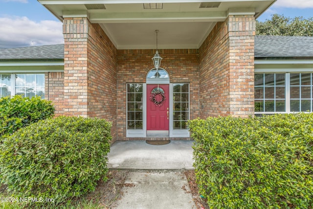 view of exterior entry with brick siding