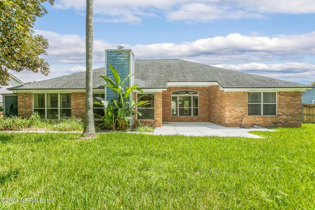 rear view of property featuring a patio area and a yard