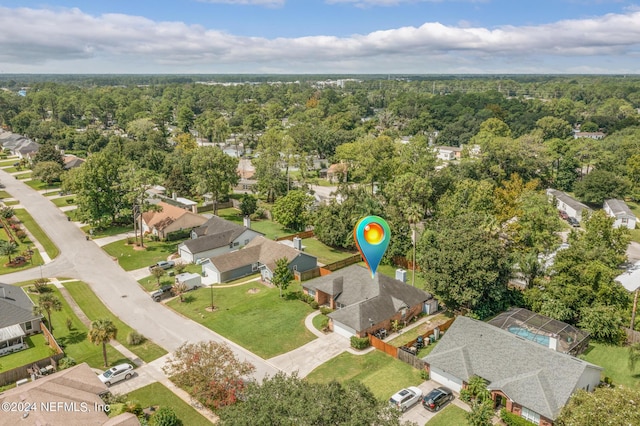 drone / aerial view with a wooded view and a residential view