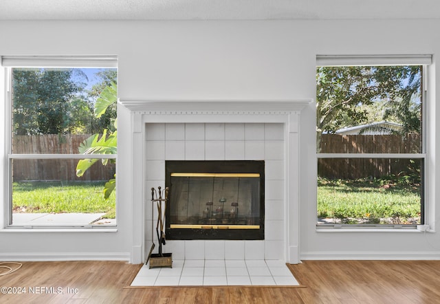 interior details with a textured ceiling, a fireplace, baseboards, and wood finished floors