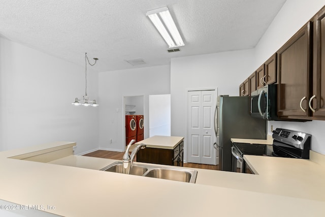 kitchen with stainless steel appliances, a sink, visible vents, light countertops, and independent washer and dryer