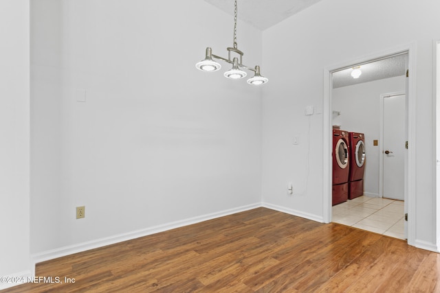 unfurnished dining area featuring a textured ceiling, baseboards, separate washer and dryer, and wood finished floors