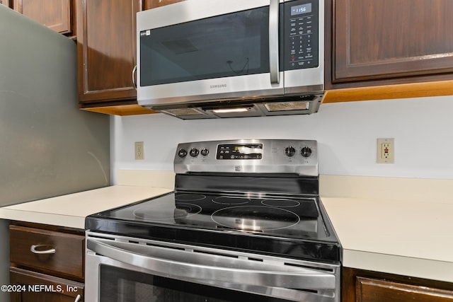 kitchen with dark brown cabinets, stainless steel appliances, and light countertops