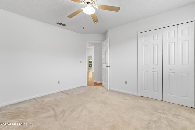 unfurnished bedroom featuring a textured ceiling, a closet, carpet, and baseboards