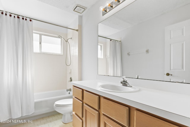 bathroom with a textured ceiling, toilet, vanity, tile patterned floors, and shower / bath combo