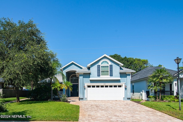 view of front of house featuring a garage and a front lawn