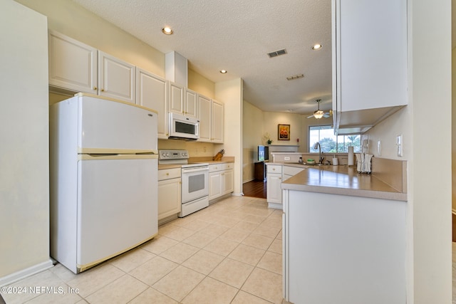 kitchen featuring kitchen peninsula, ceiling fan, a textured ceiling, white appliances, and white cabinets