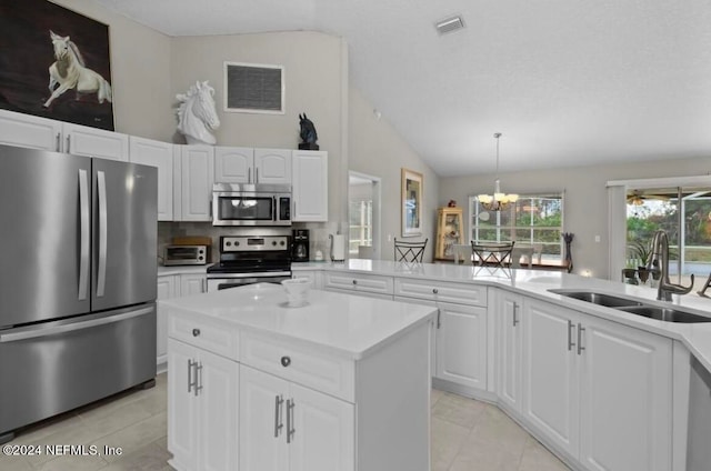 kitchen with pendant lighting, light tile patterned floors, appliances with stainless steel finishes, sink, and white cabinetry