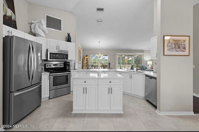 kitchen featuring high vaulted ceiling, stainless steel appliances, white cabinetry, light tile patterned floors, and kitchen peninsula