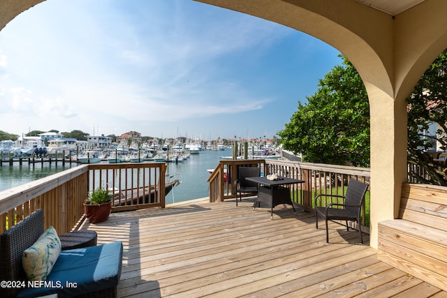 wooden deck with a boat dock and a water view