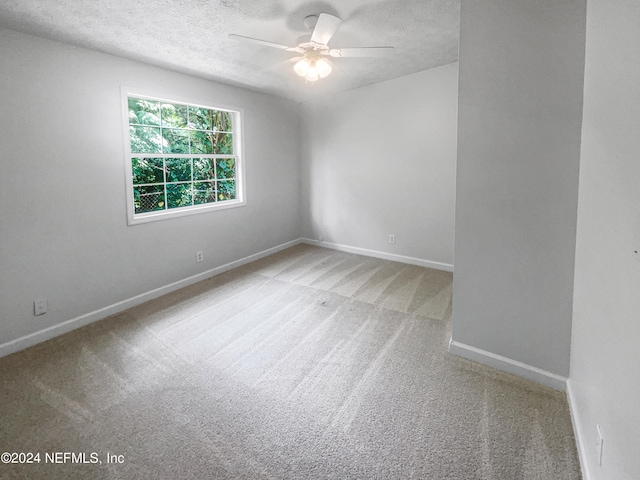 unfurnished room with a textured ceiling, carpet, and ceiling fan