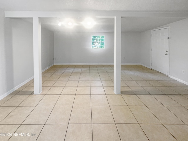 basement with a textured ceiling and light tile patterned floors