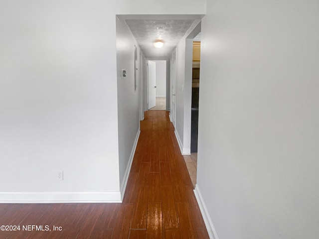 hallway featuring hardwood / wood-style flooring and a textured ceiling