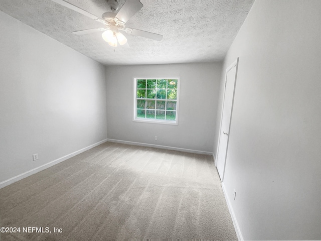 carpeted empty room featuring a textured ceiling and ceiling fan