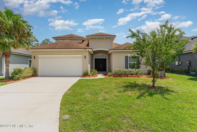 mediterranean / spanish-style house with a garage and a front yard