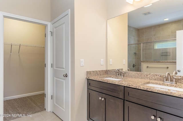 bathroom featuring vanity, tile patterned flooring, and a shower with door