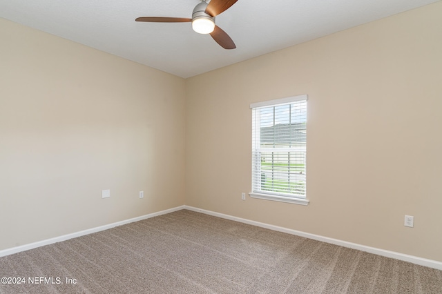 carpeted spare room with ceiling fan