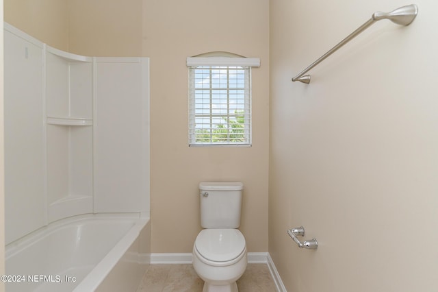 bathroom with tile patterned floors, washtub / shower combination, and toilet