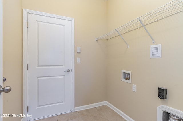 washroom with hookup for a washing machine and light tile patterned flooring