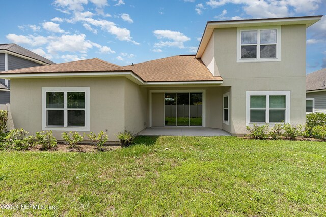 back of house with a lawn and a patio area