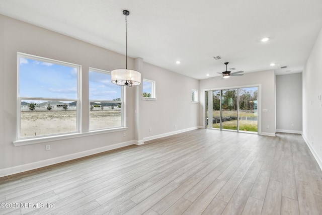 interior space with ceiling fan with notable chandelier and light hardwood / wood-style floors