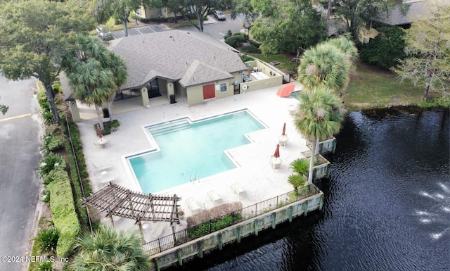 view of swimming pool with a water view and a patio