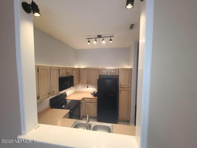 kitchen with black appliances, sink, and light brown cabinets