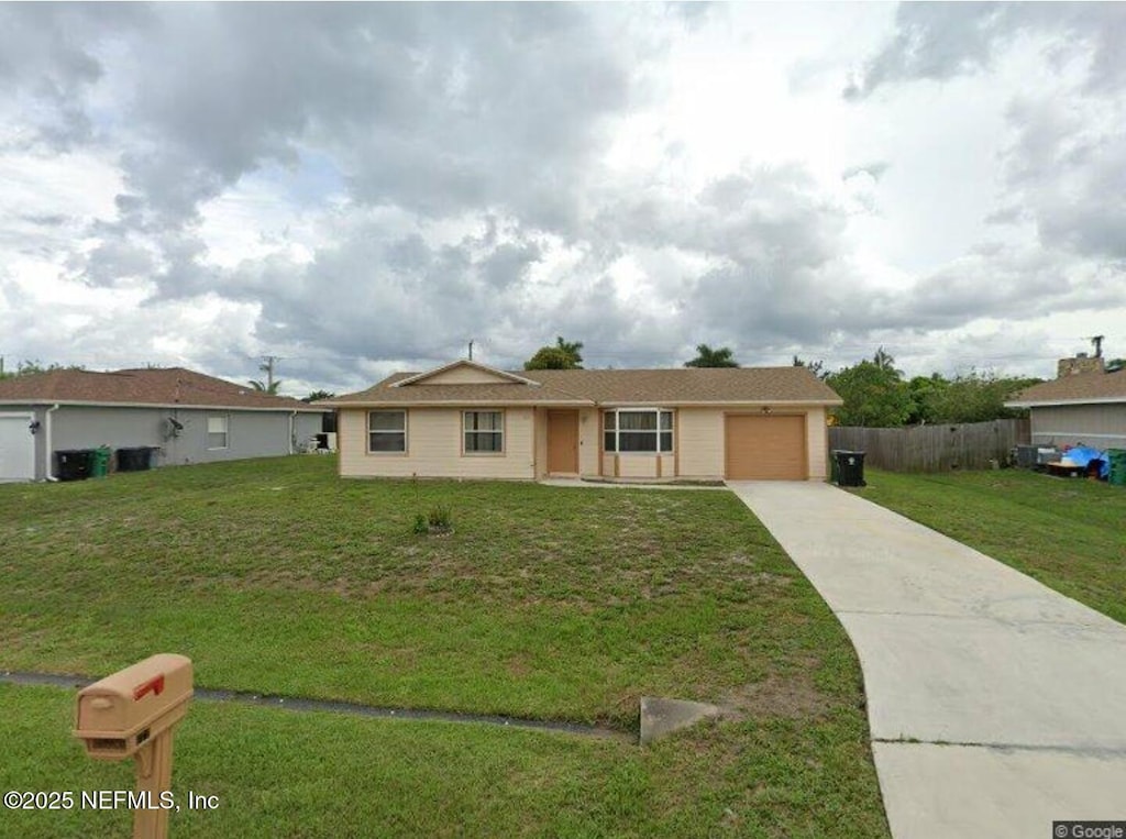 ranch-style home with a garage and a front lawn