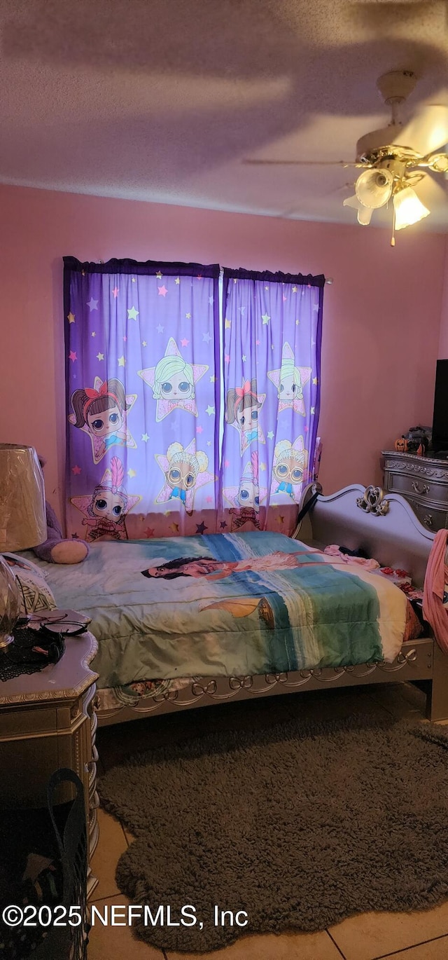 bedroom featuring ceiling fan and a textured ceiling