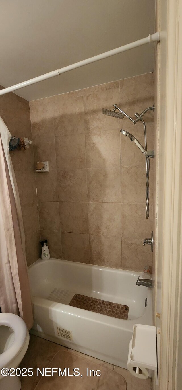 bathroom featuring shower / bath combination with curtain, tile patterned floors, and toilet