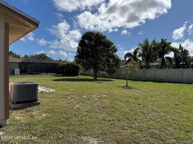 view of yard featuring a lanai and central air condition unit