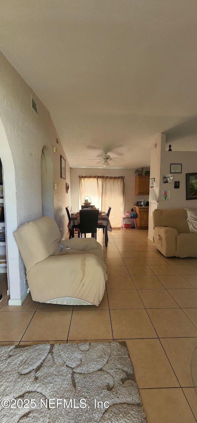 tiled living room featuring ceiling fan