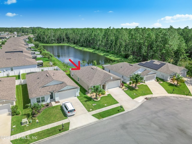 bird's eye view featuring a residential view, a water view, and a wooded view