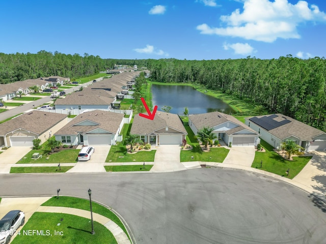 birds eye view of property featuring a forest view, a water view, and a residential view