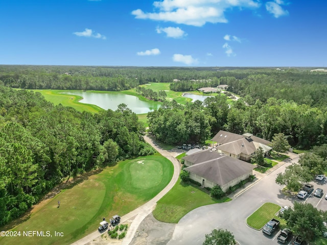 drone / aerial view with a forest view, golf course view, and a water view