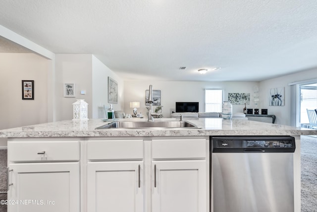 kitchen featuring light countertops, open floor plan, white cabinets, a sink, and dishwasher