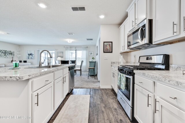 kitchen featuring dark wood-type flooring, white cabinetry, appliances with stainless steel finishes, sink, and a textured ceiling