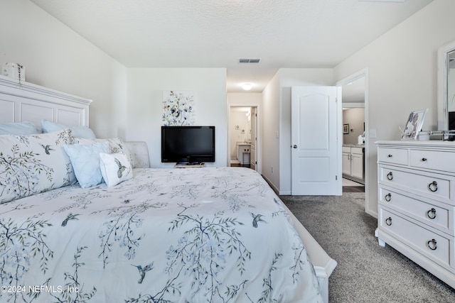 bedroom with dark colored carpet and ensuite bath