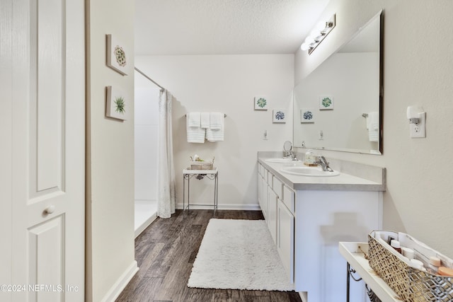 bathroom featuring curtained shower, double vanity, a textured ceiling, and wood finished floors