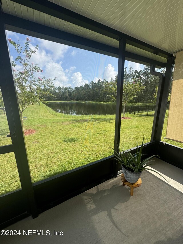 unfurnished sunroom featuring a wealth of natural light and a water view