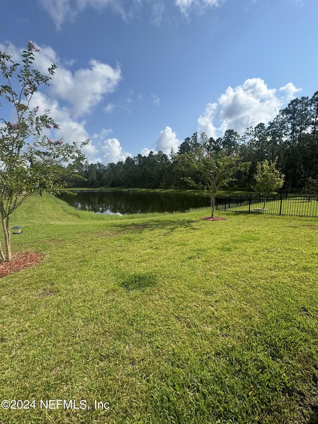 view of yard with a water view and fence