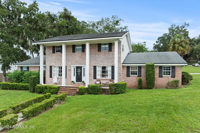 greek revival house featuring a front yard