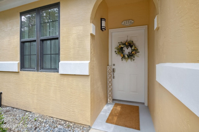 doorway to property featuring stucco siding