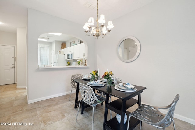 dining room with visible vents, a chandelier, arched walkways, and baseboards