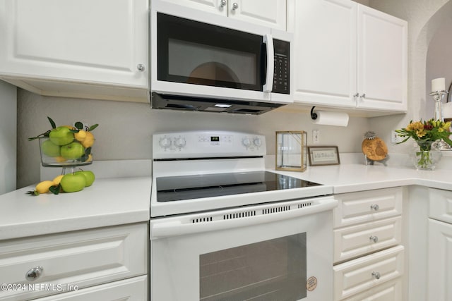 kitchen with light countertops, white appliances, and white cabinets