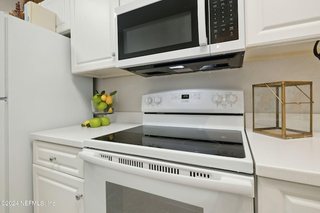 kitchen with light countertops, white appliances, and white cabinetry