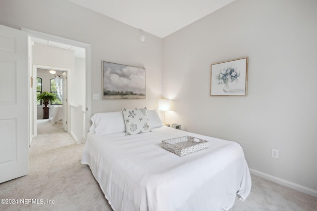 bedroom with baseboards and light colored carpet